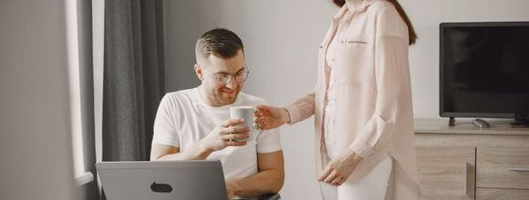 Man being passed a coffee mug in supported living house